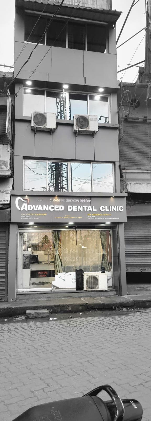 Exterior of Advanced Dental Clinic, a multi-story building with large windows and prominent signage.